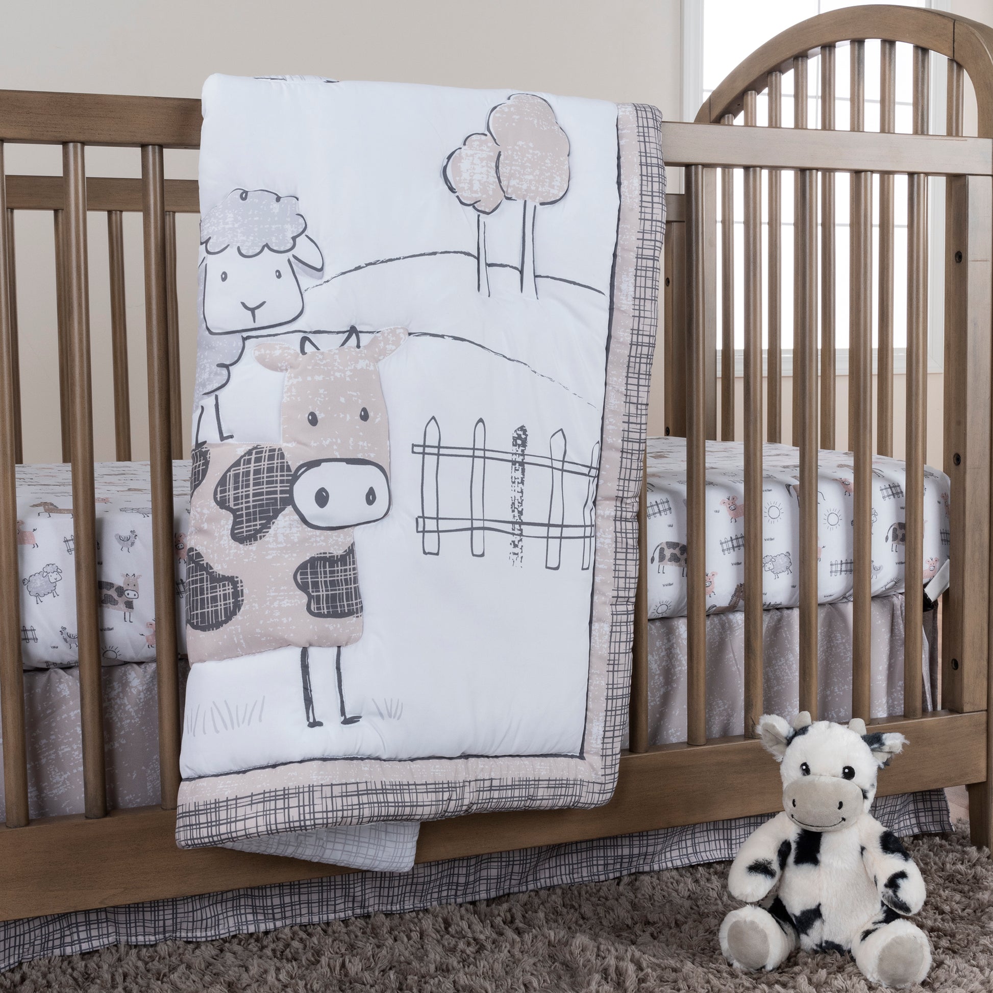  Cottage Farm 4 Piece Crib Bedding Set main image in stylized room; Bedding set features a cow, sheep, pig, and chicken out playing in a simple pasture. Grays, browns and a rosy pink color scheme will add the perfect last touch to your little farmer's nur