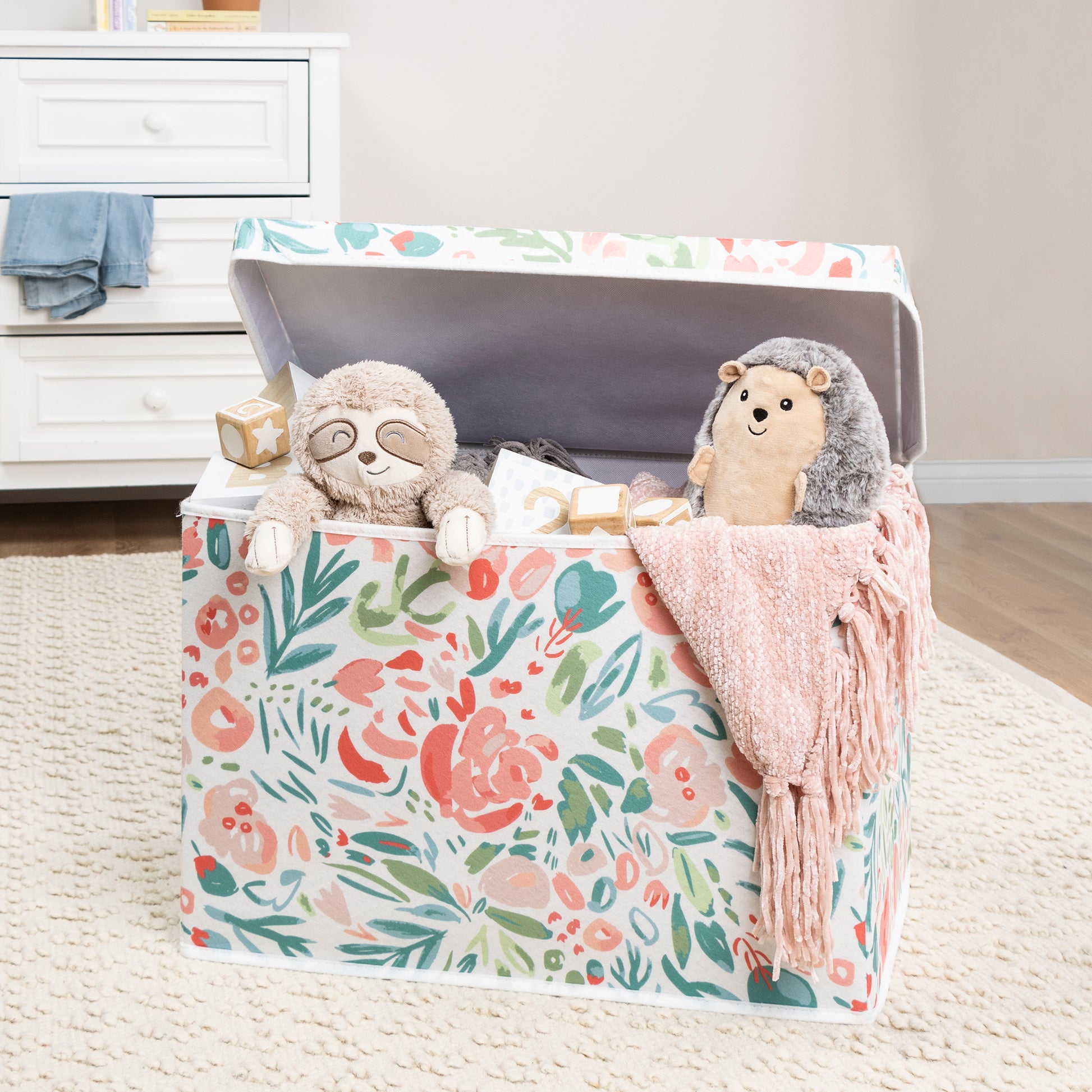 Painterly Floral Felt Toy Box by Sammy & Lou® with lid open with toys and stuffed animals peeking out