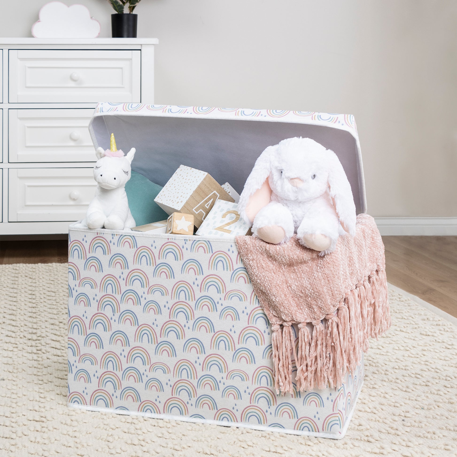 Painted Rainbow Felt Toy Box by Sammy & Lou® with lid open with toys and stuffed animals peeking out