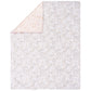 Nursery quilt measuring 35 in x 45 in and features sweet little cottontail bunnies surrounded by flowers in soft pink, rose, opal gray and mushroom on one side and simple sweet coordinating white and rose florals on a soft pink background on the other.