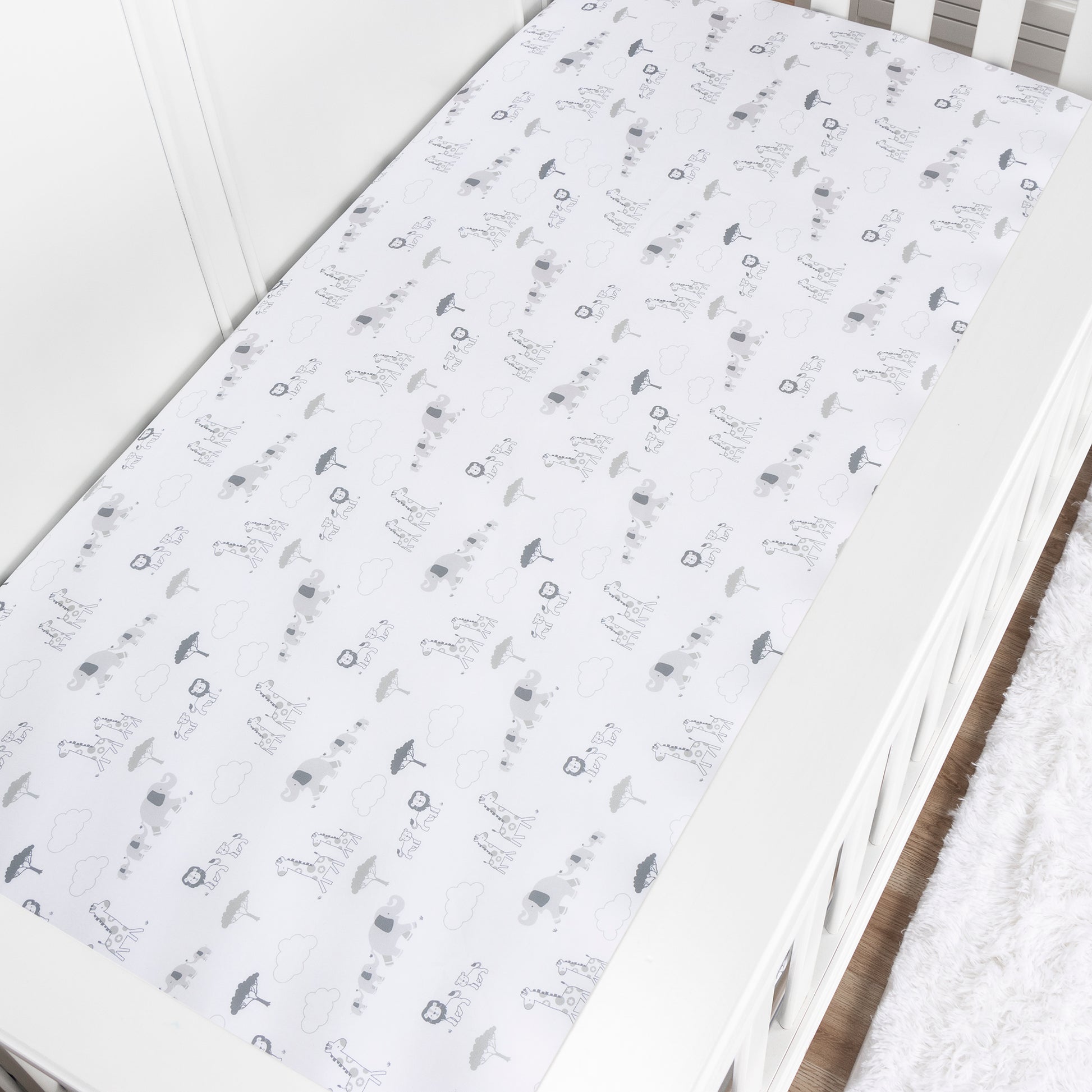 stylized in nursery image of follow the leader crib sheet featured on a white crib