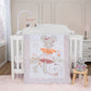 Dancing Mouse 4 Piece Crib Bedding Set by Sammy & Lou® in a stylized bedroom.  The nursery quilt, crib sheet and skirt sit on a modern white crib with the mouse plush toy in front of the crib. A night stand sits to the right with a pink lamp, and floral musical mobile sits above the crib.