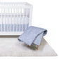 Save The Polar Bears Bedding Set with Main Crib Sheet and Skirt on a crib, and the quilt on a stool next to the crib